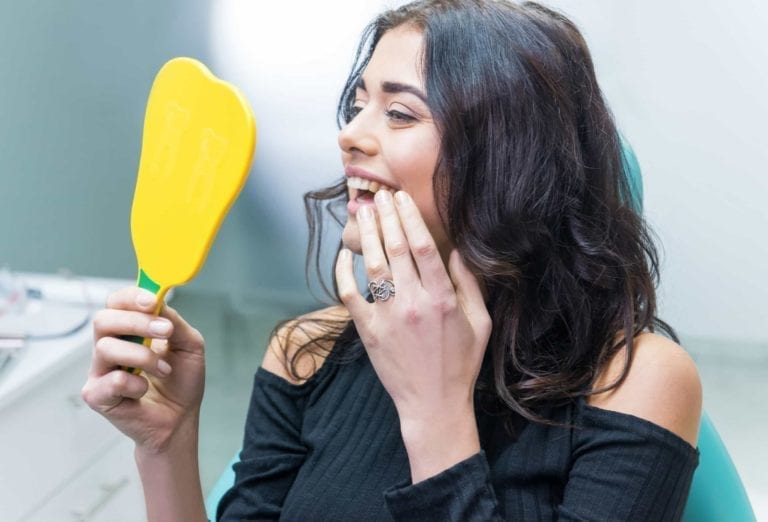 Beautiful Girl Checking her teeth in mirror